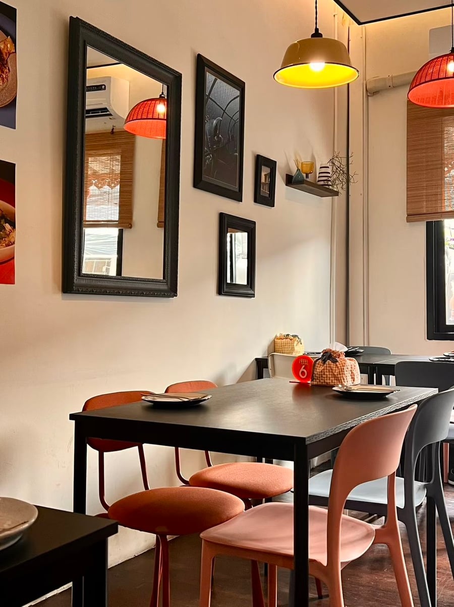 The second-floor dining room, with red and yellow pendant lamps and terracotta chairs